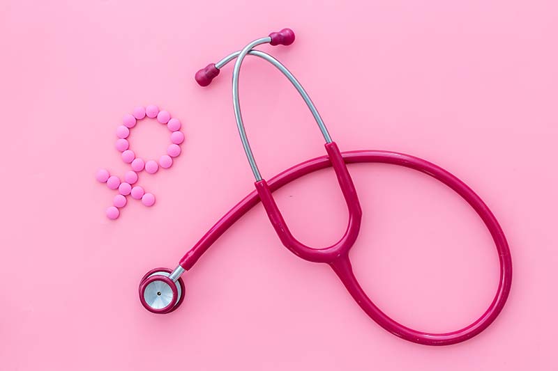 Pink stethoscope with female gender symbol on pink background to represent Women's Health Services provided by our Melbourne doctors