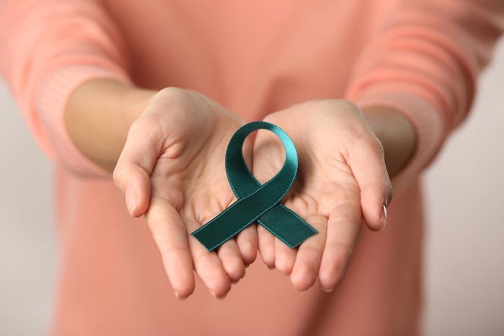 Woman holding a ribbon in open hands for cervical cancer awareness