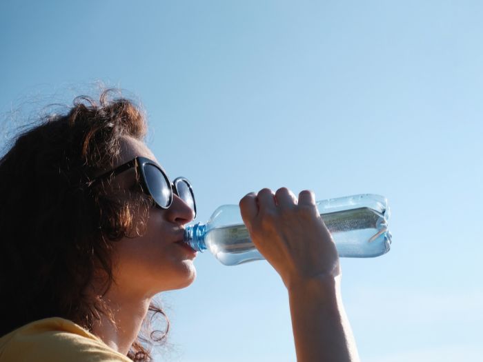 Woman drinking water on a hot day